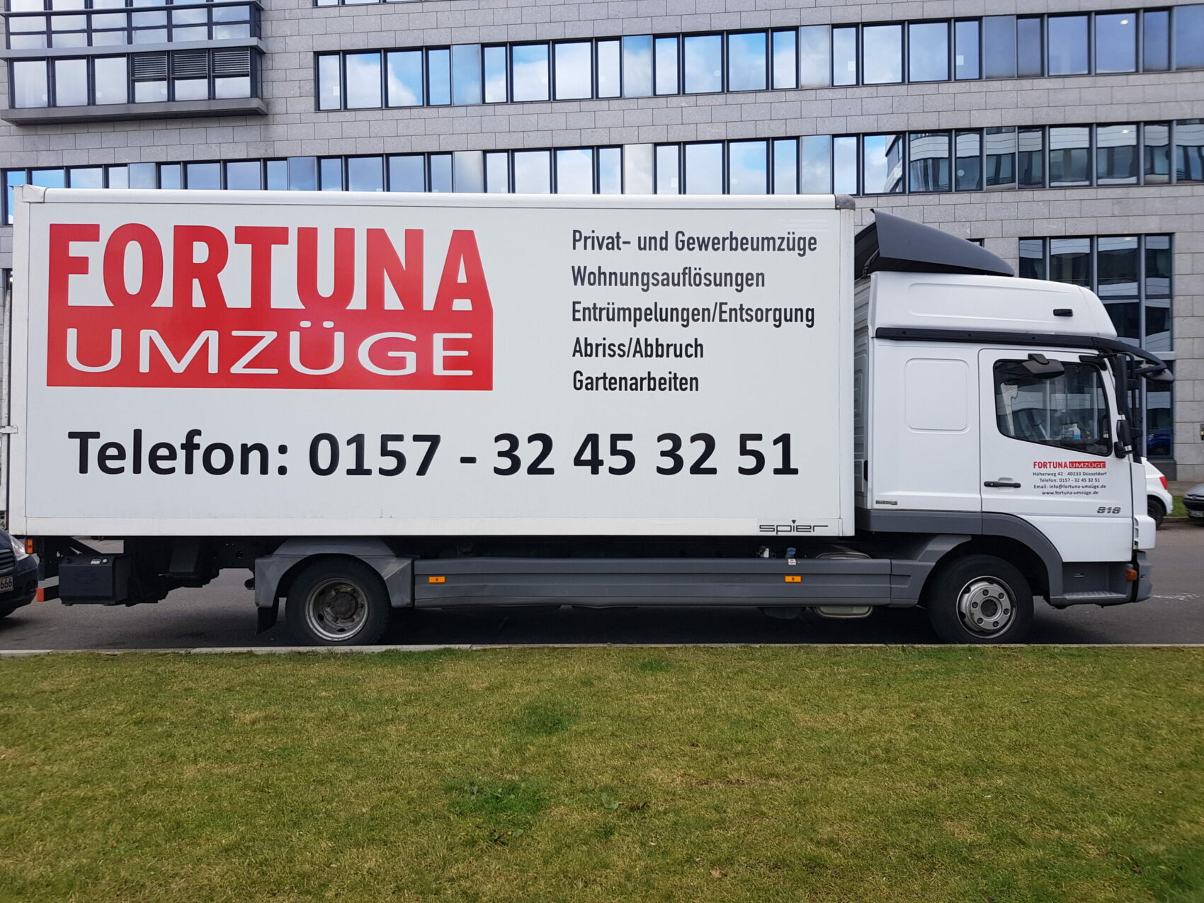 Lkw von Fortuna Umzüge mit Firmenlogo, Leistungsübersicht und Telefonnummer auf der Seitenfläche